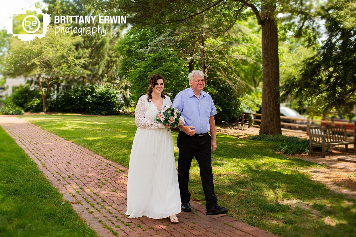 Bride-walking-down-aisle-outdoor-brick-path-small-wedding-in-park.jpg