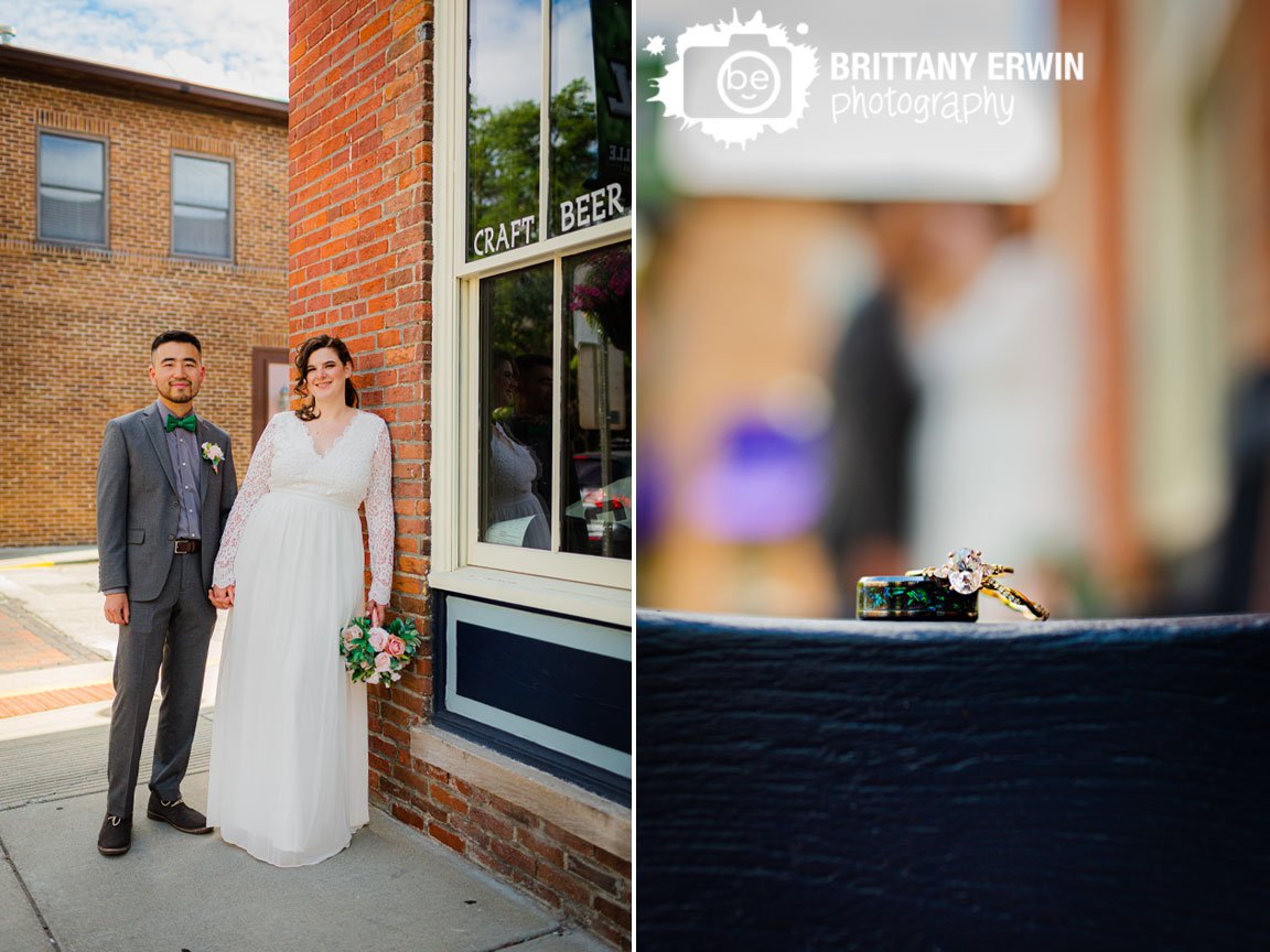 wedding-bands-with-engagement-ring-on-bench-with-couple-downtown-Zionsville.jpg