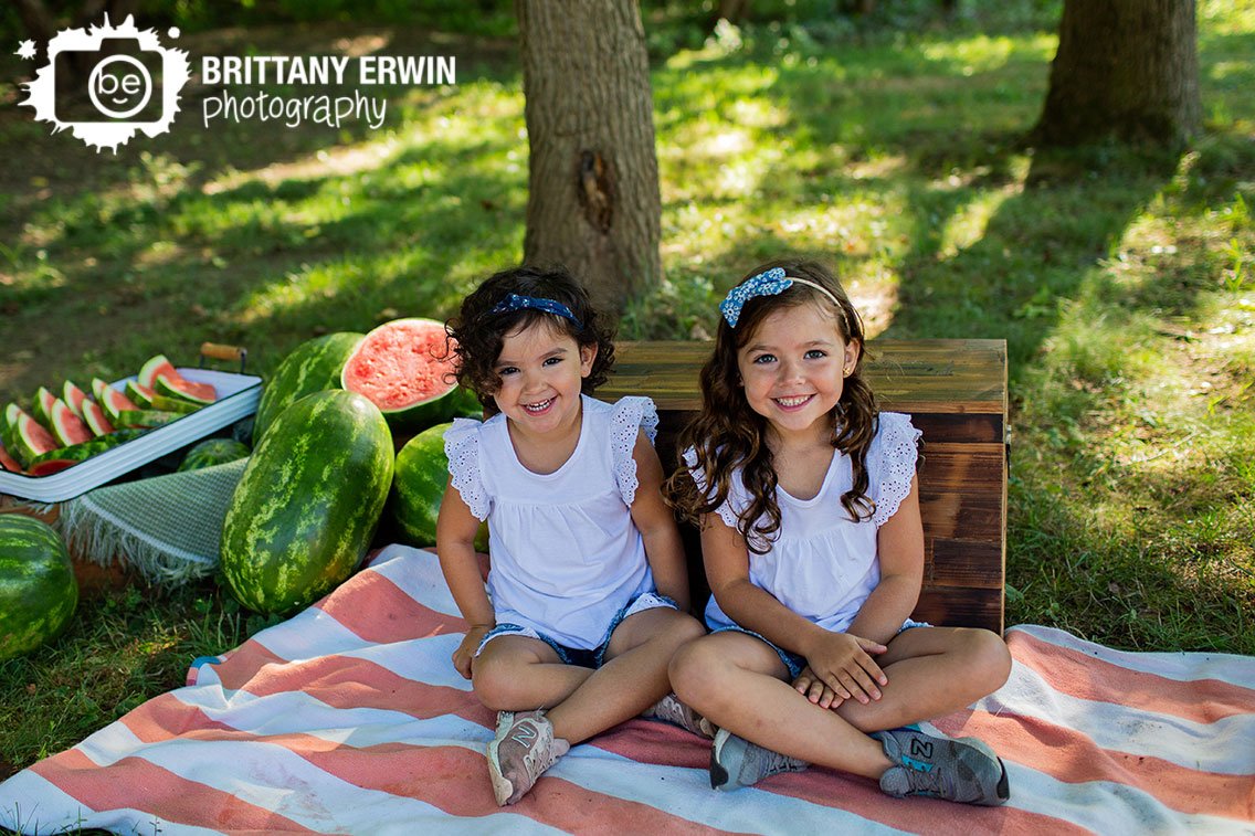 sisters-on-picnic-blanket-with-crate-summer-portrait.jpg