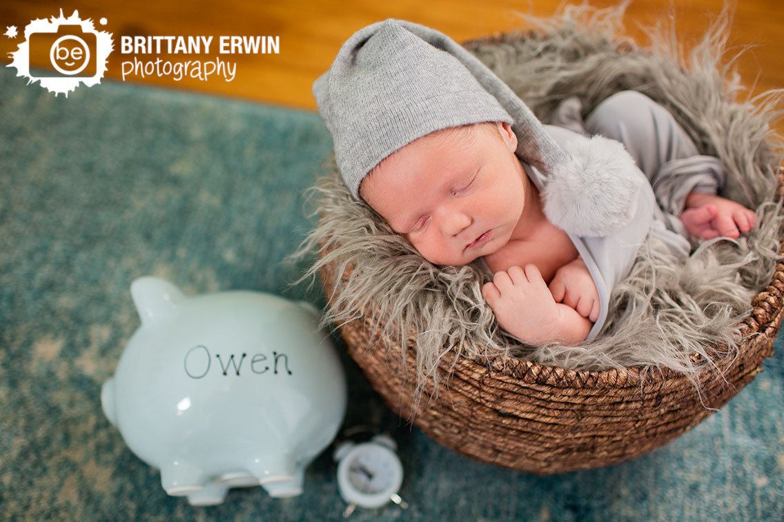 Indianapolis-newborn-photographer-in-home-baby-boy-in-basket-sleeping-with-piggie-bank.jpg