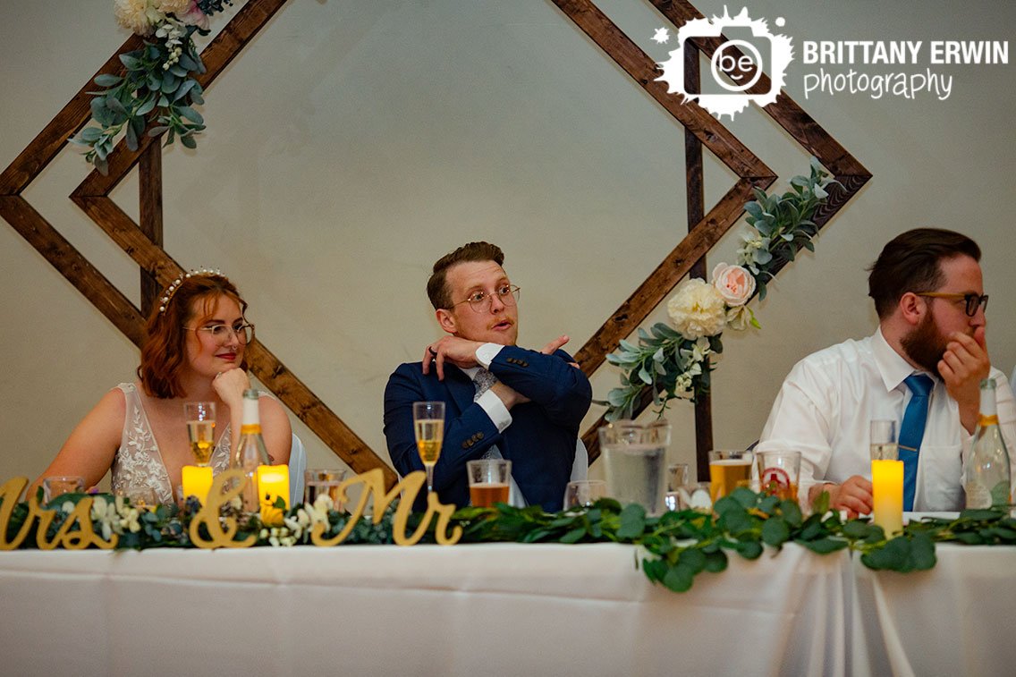 Couple-at-head-table-groom-giving-hints-at-live-trivia.jpg