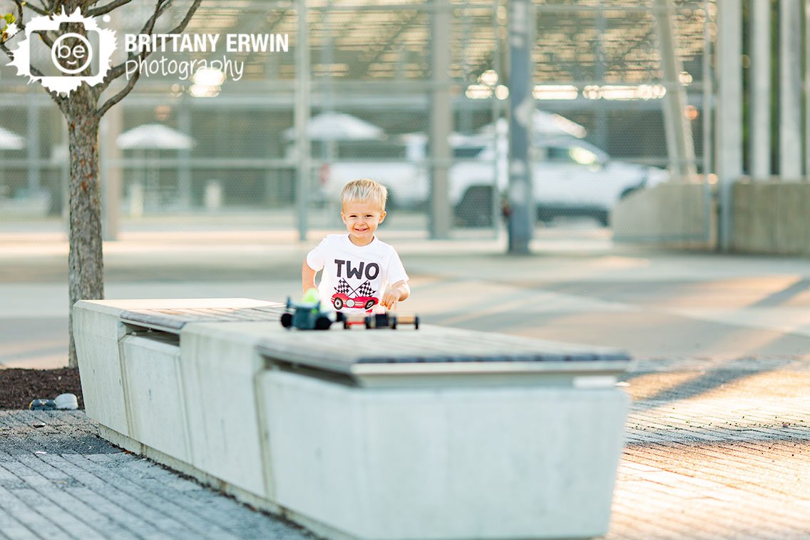two-fast-boy-playing-with-race-cars-on-bench-outside-IMS.jpg