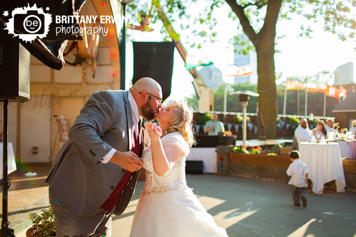 Outdoor-wedding-reception-photographer-couple-cut-cake-kiss.jpg