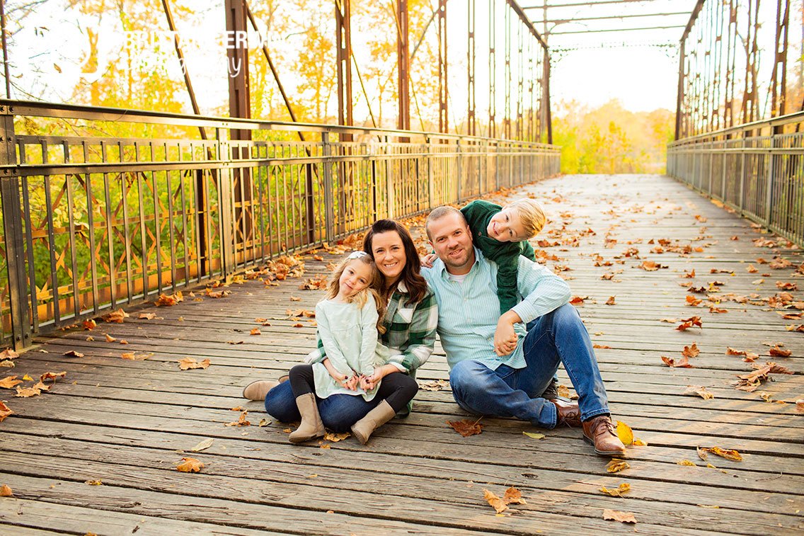Indianapolis-family-portrait-photographer-group-sitting-on-bridge-with-fall-leaves.jpg