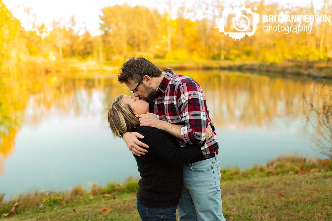 Indianapolis-engagement-portrait-photographer-couple-kiss-by-pond-fall-trees.jpg