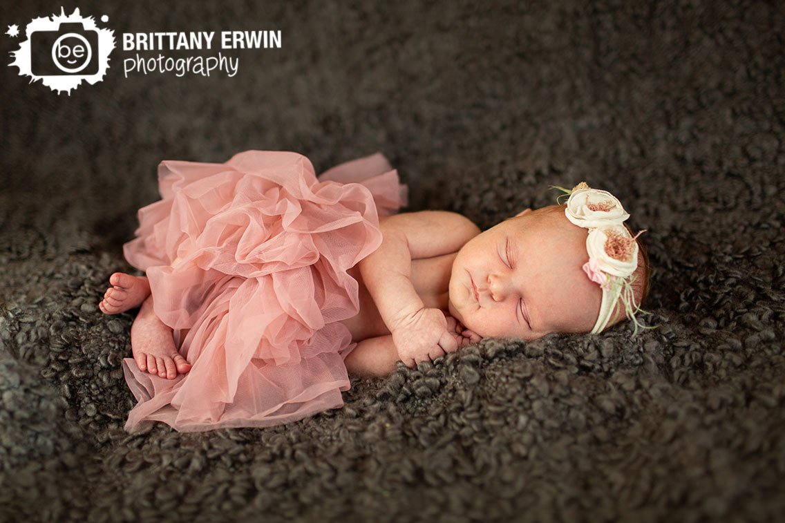 Indianapolis-newborn-portrait-photographer-baby-girl-sleeping-in-pink-tutu-with-flower-headband.jpg