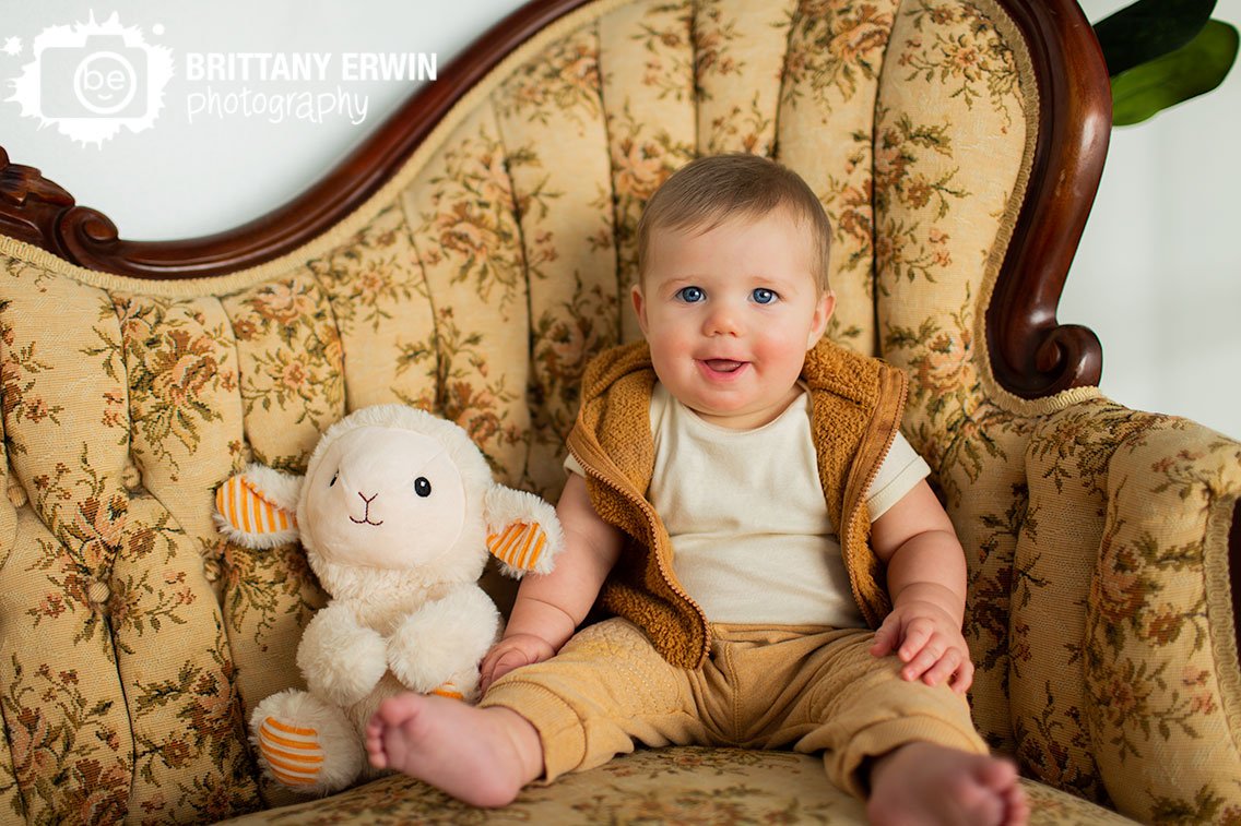 baby-boy-with-lamb-stuffy-sitting-on-antique-couch-at-Nerdy-Fox-Rentals-studio.jpg