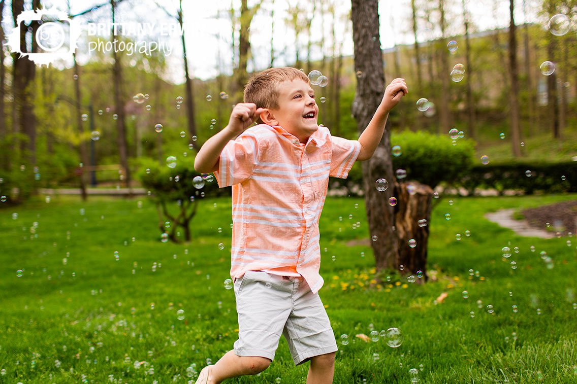 spring-portrait-photographer-boy-playing-in-park-full-of-bubbles.jpg
