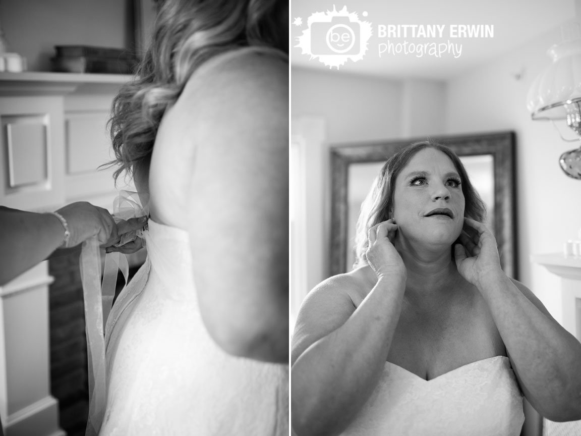 Indianapolis-wedding-photographer-bride-putting-earrings-in-and-having-belt-tied-over-gown.jpg