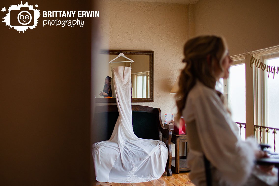 Bride-getting-ready-dress-hanging-from-mirror.jpg