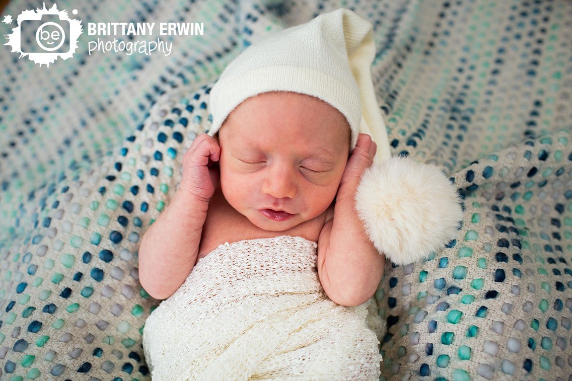 baby-boy-sleeping-on-textured-blue-blanket-white-sleeping-cap.jpg