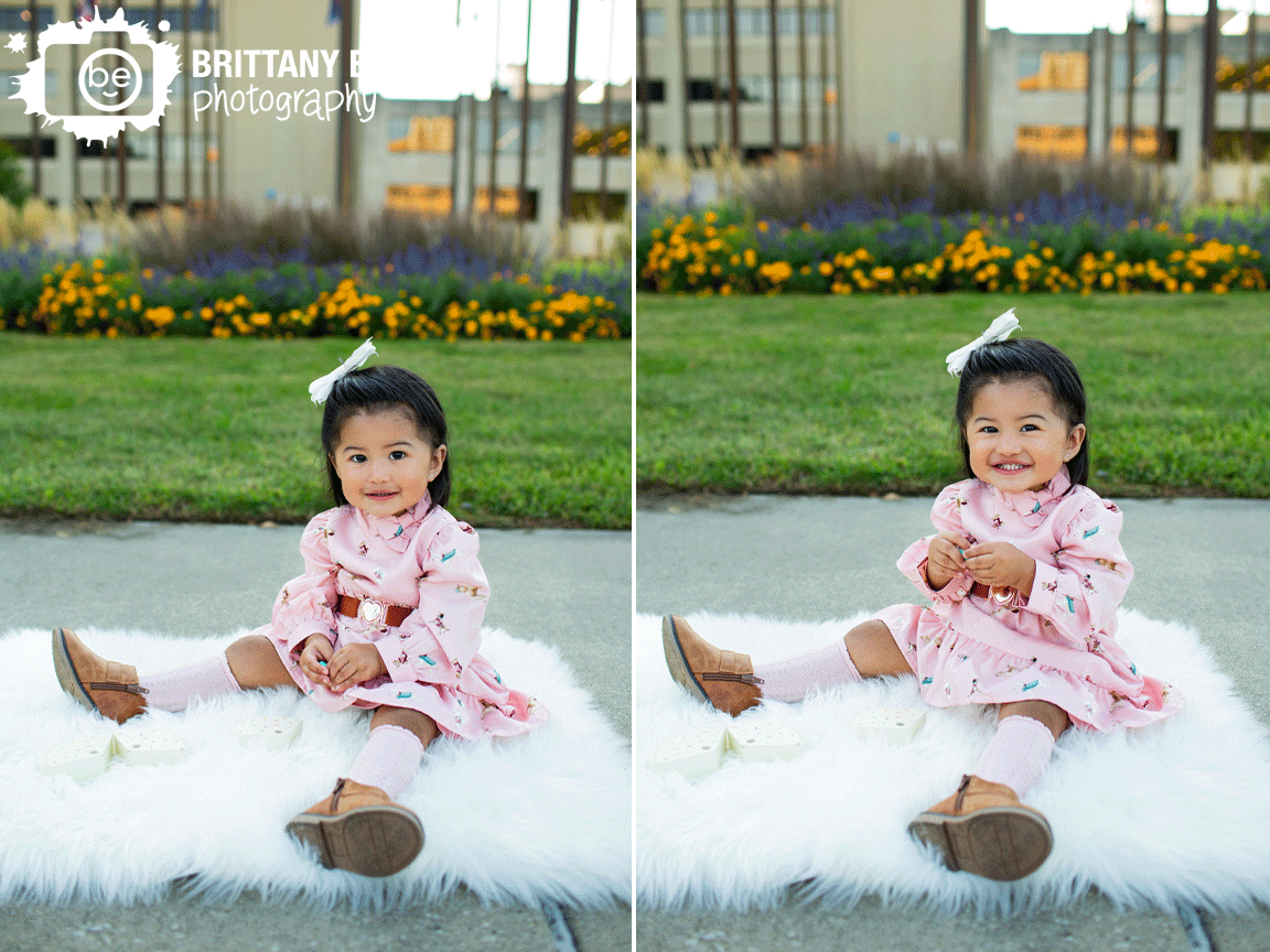 Downtown-Indianapolis-portrait-photographer-first-birthday-girl-on-fur-rug-by-flowers-outside.gif