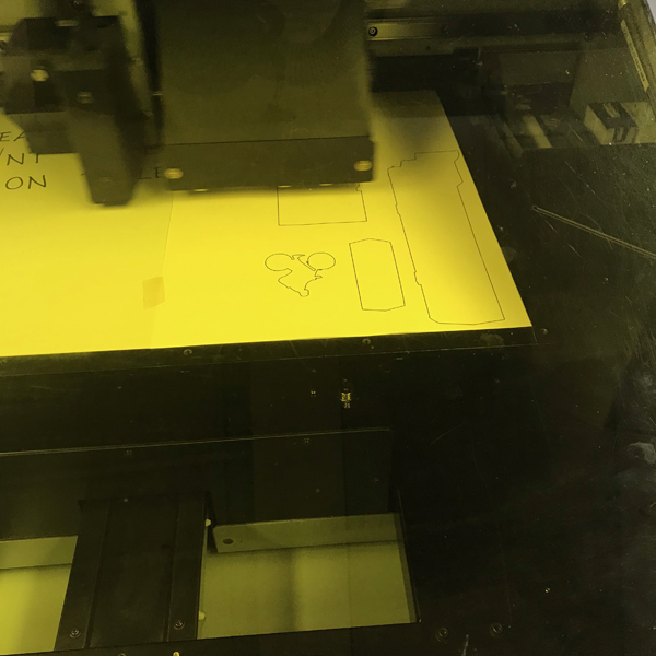 Once the outlines are printed, line up your material with the outlines. In Fernando's case we were printing on 1/8th inch acrylic.