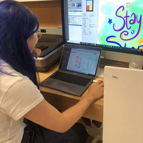 Qixuan Wang of Products of Design MFA is using the Roland vinyl printer to print a poster for a Design and Politics design sprint. 