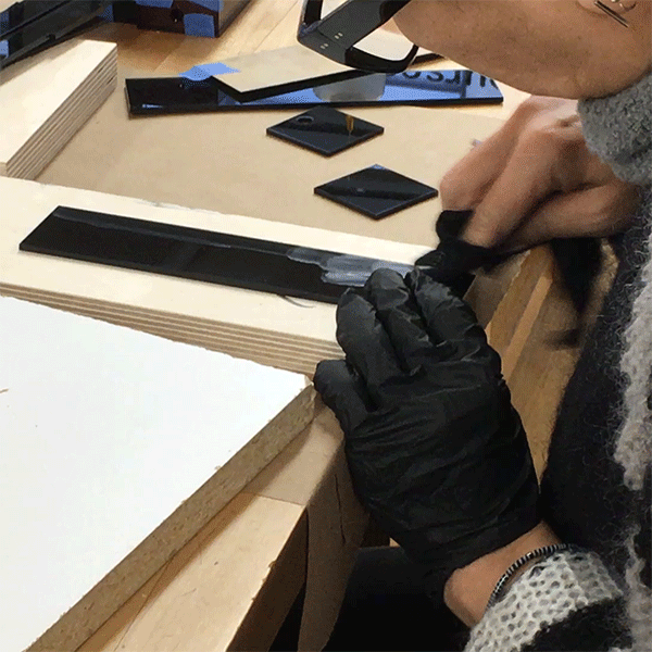 The Visible Futures Lab's artist in residence Chika is gluing up the parts to her acrylic light boxes with solvent cement and buffing out excess smudges.