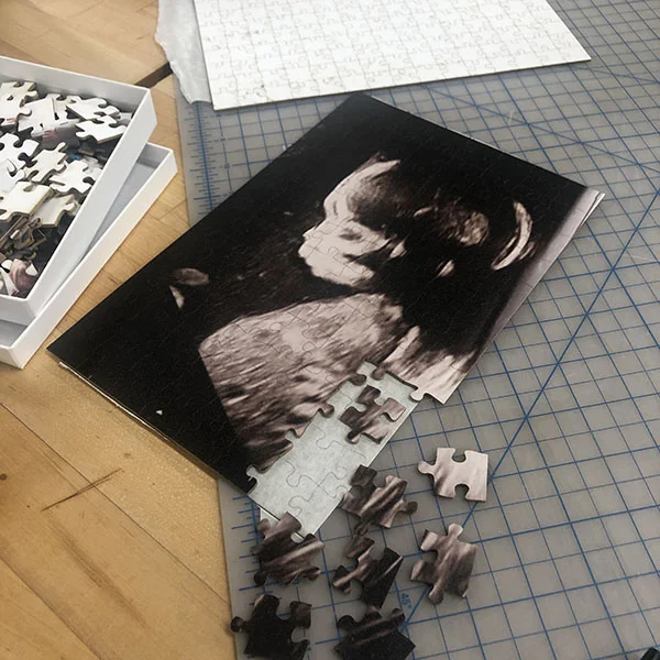 She's printing various sentimental photos of family members and cutting them into puzzle