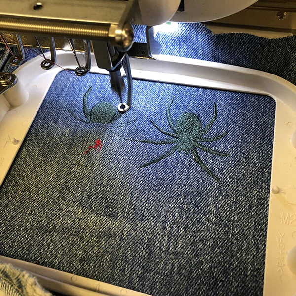 In the first image above, you can see how EPS files appear in the embroidery software and how it simulates different stitch types. This is how it starts to show up on denim.