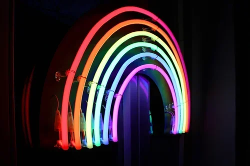 Colorful rainbow-shaped neon lights on a wall.
