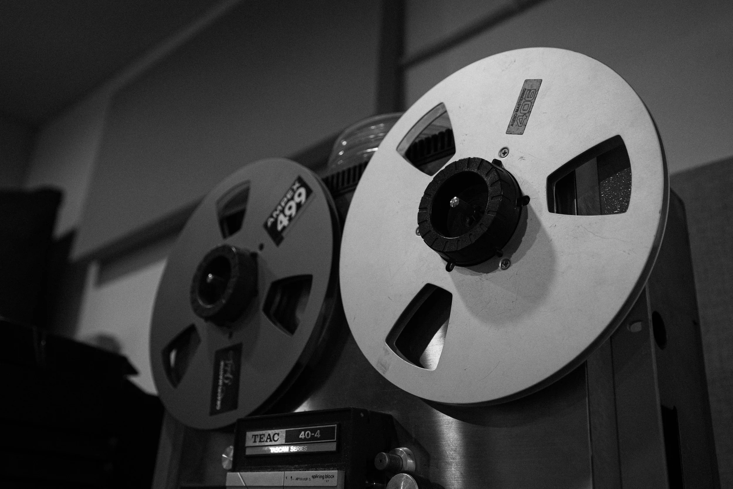 Two black-and-white film reels on a metallic machine, with labels indicating 40-4 and TEAC 40-4, in an indoor setting.