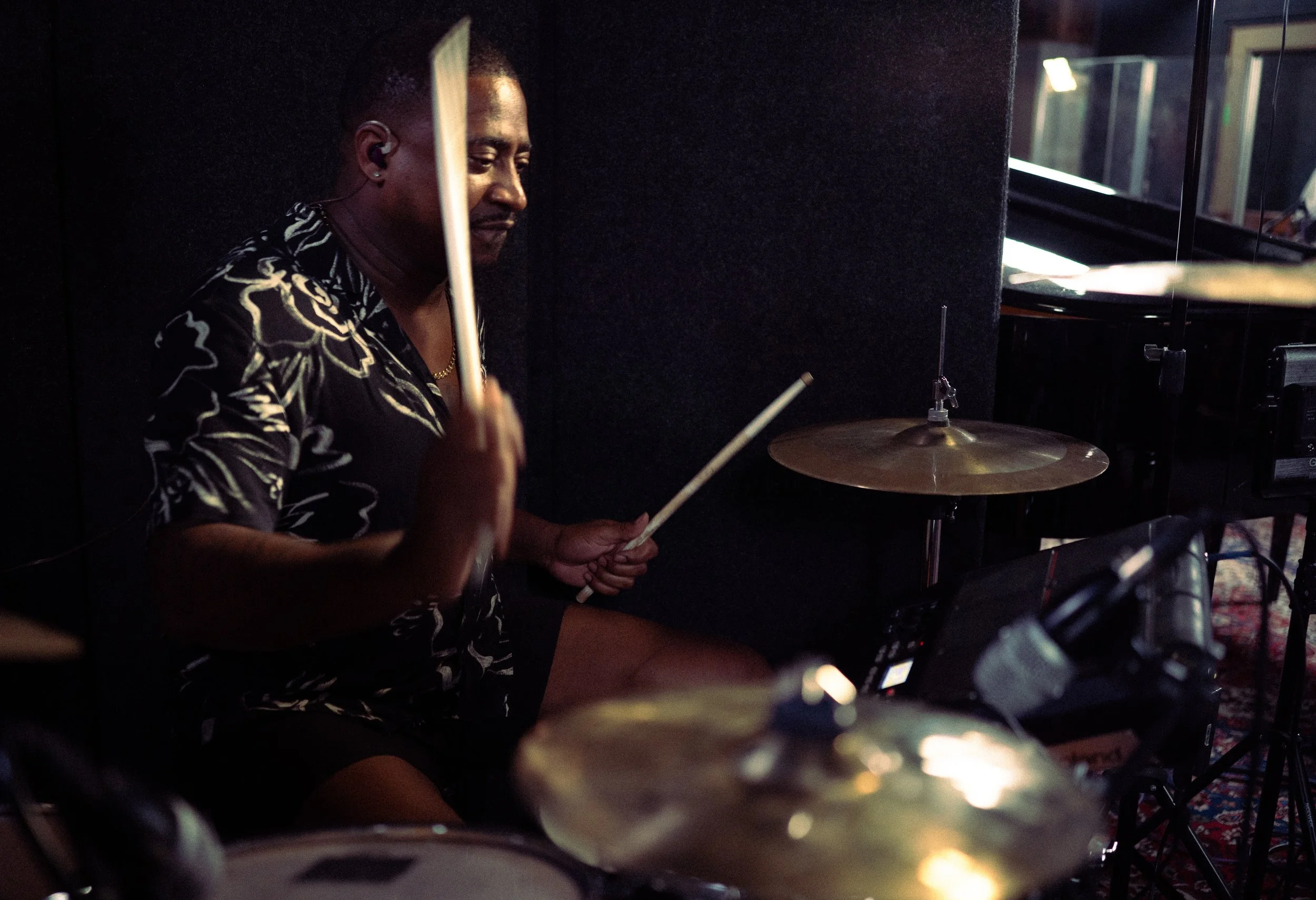 A person playing drums in a dimly lit room.