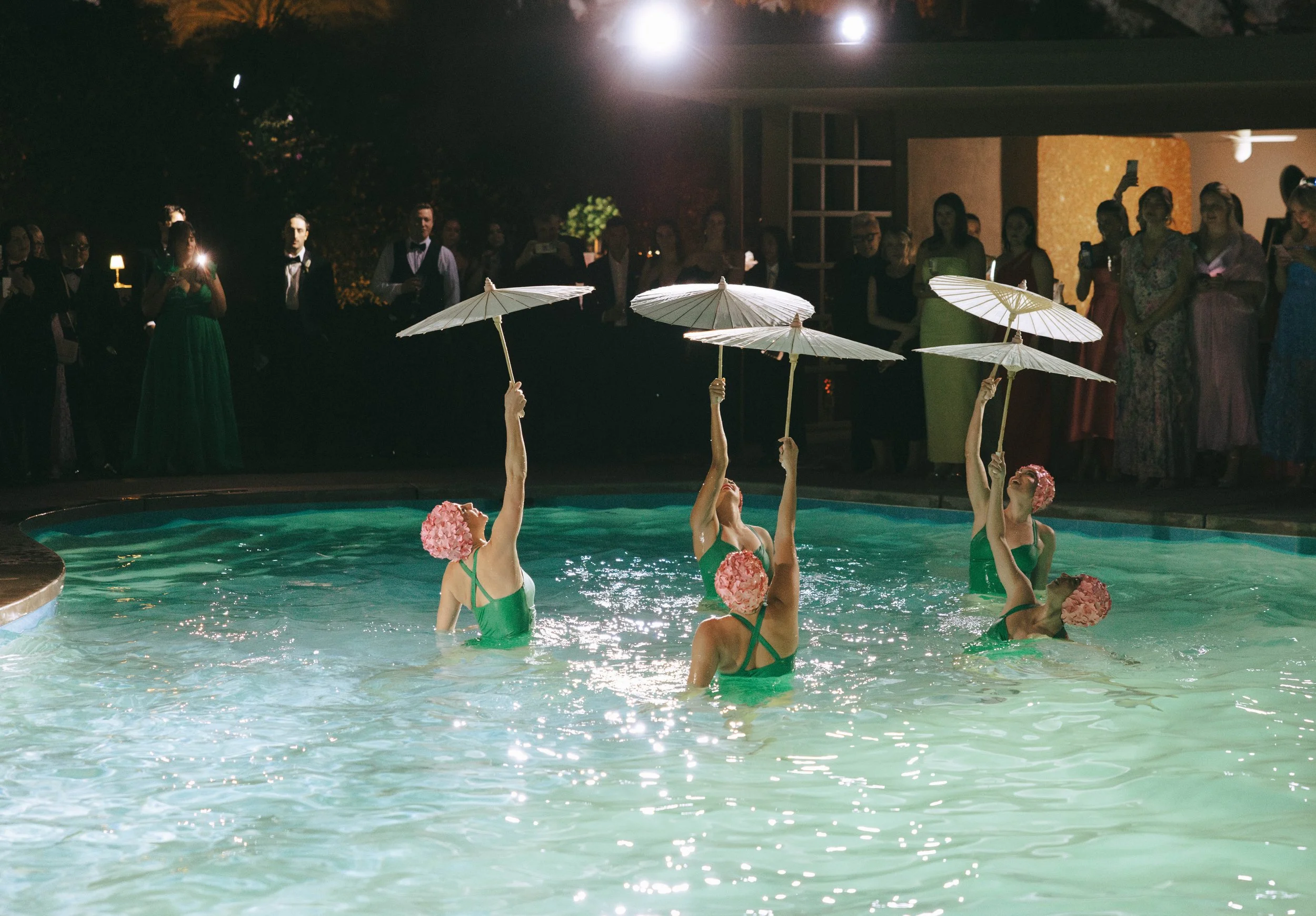Synchronized Swimmers entertain during cocktail hour in a poolside reception the guests love 