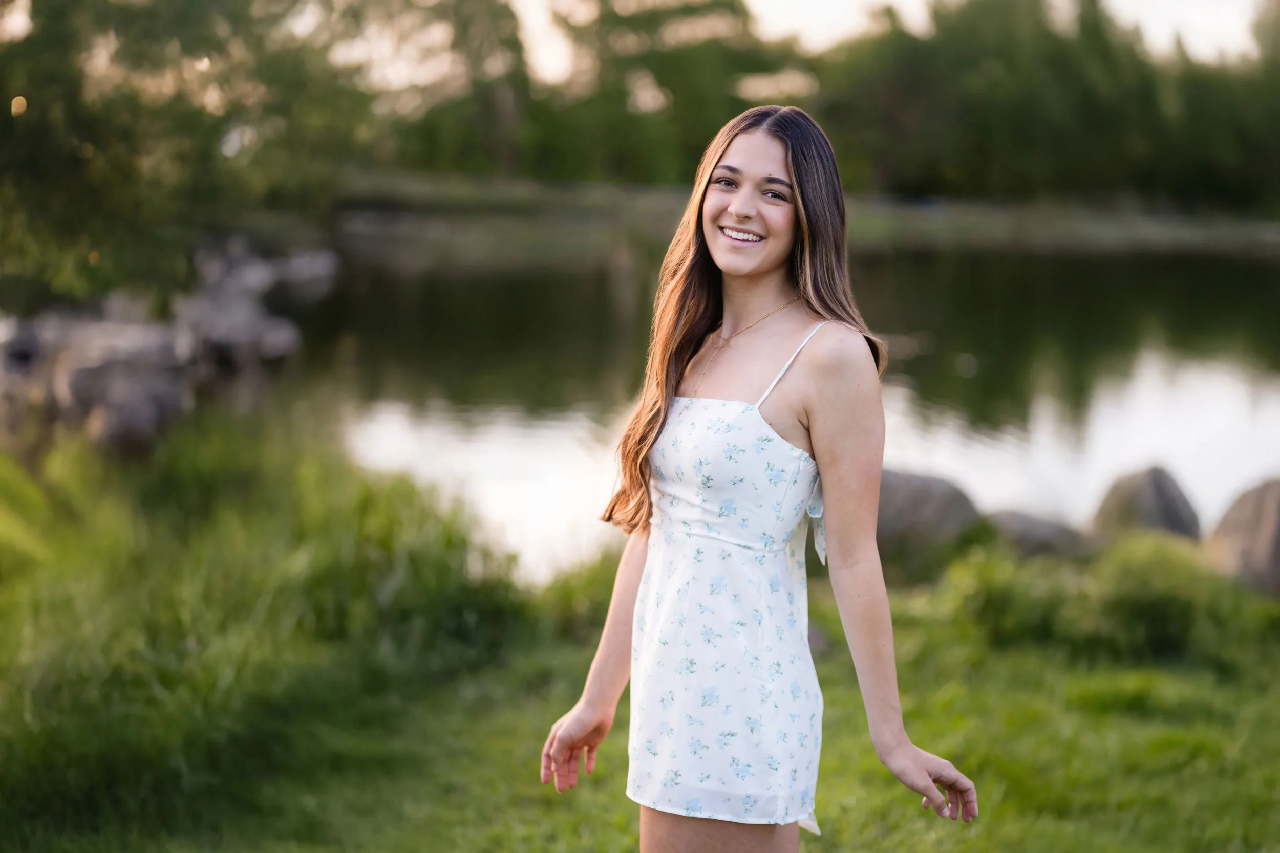 High school senior Olivia twirls on the grass in front the pond at Bywater Hollow Lavender Farm in Lincoln, California in the spring of 2026