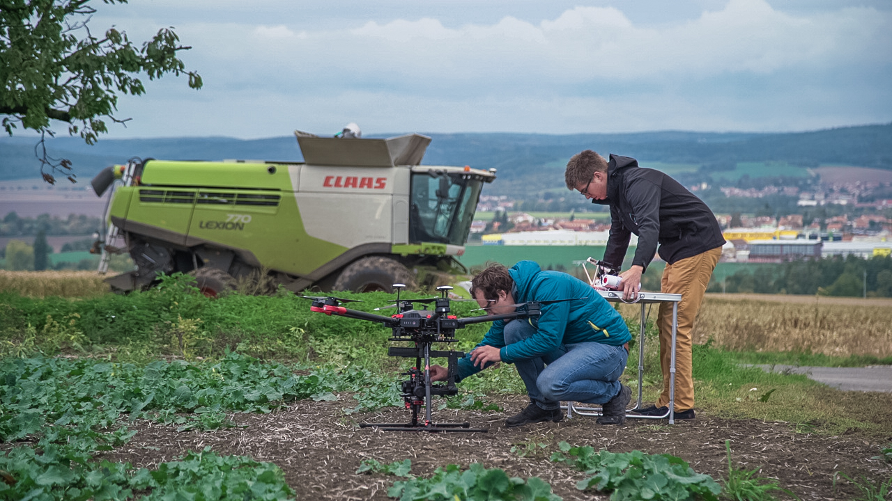 Agricultural drone with combine in the background