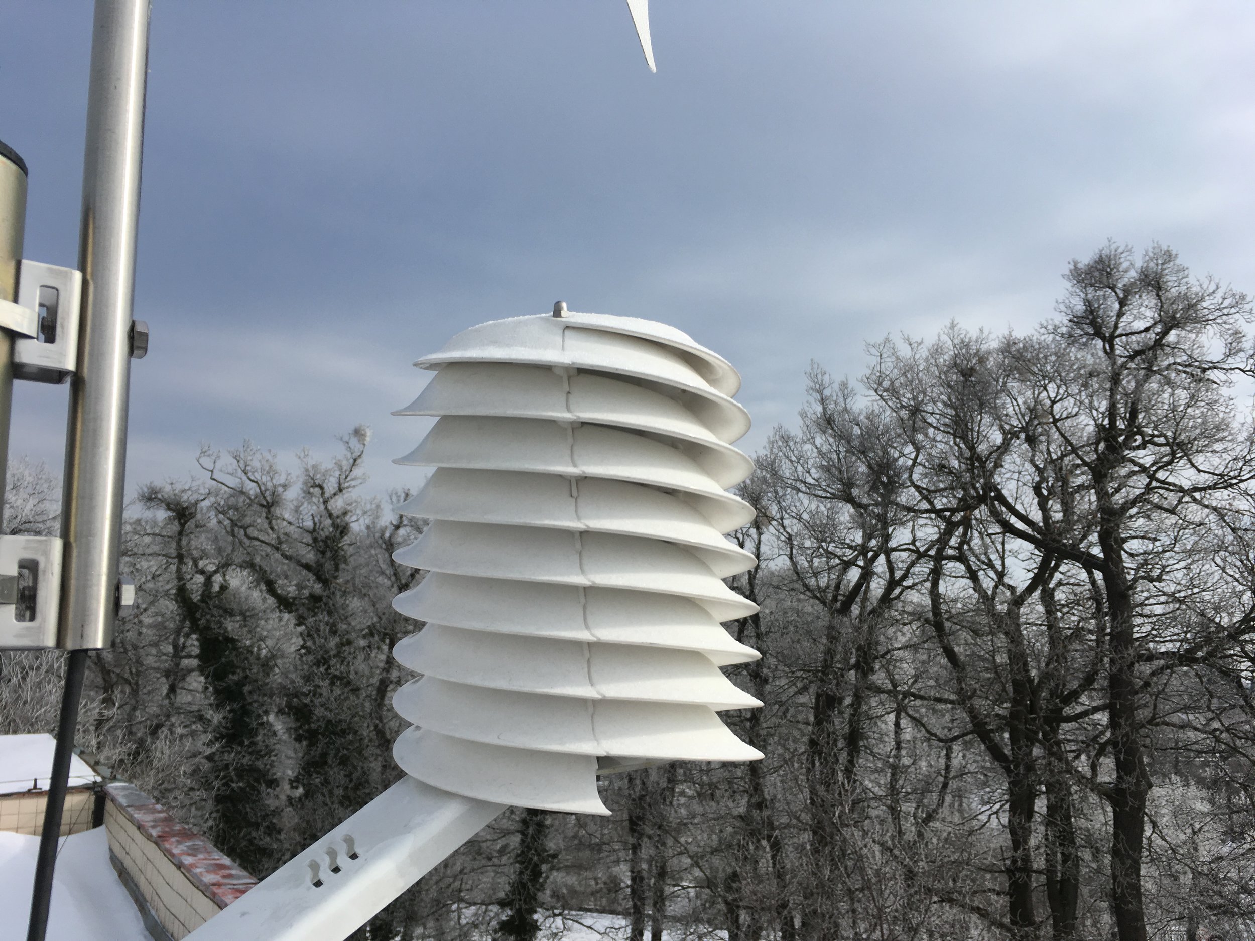 Radiation shield with trees and mostly cloudy sky