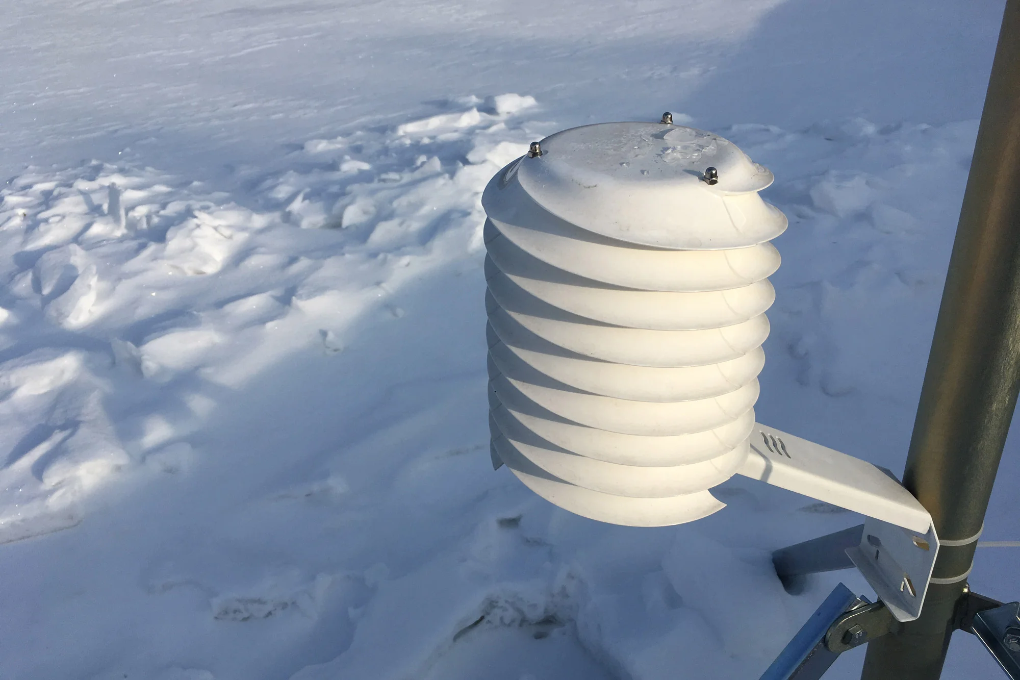 Radiation shield in the sun over snow field - MeteoShield Standard