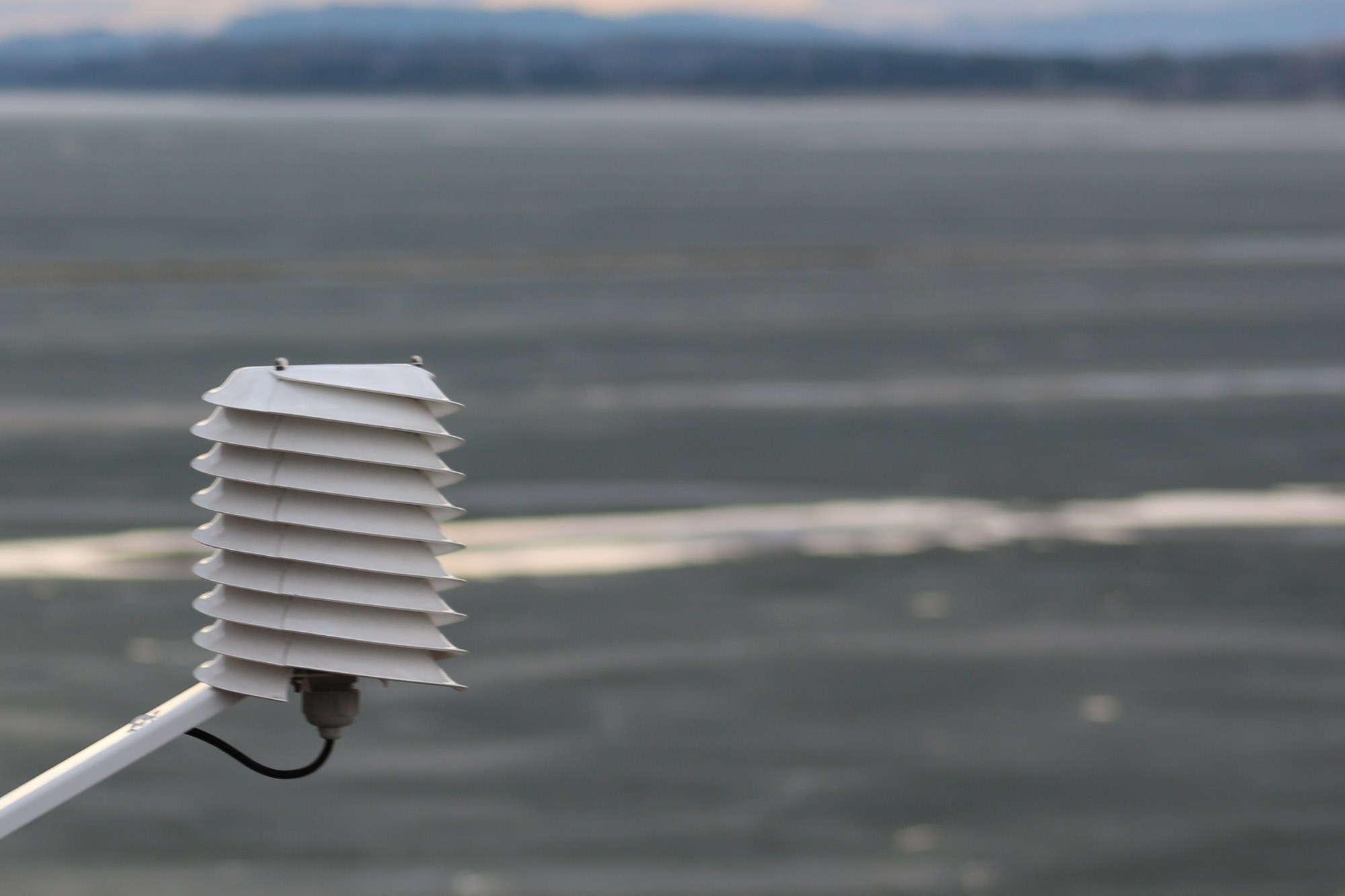 Radiation shield monitoring air temperature near a lake