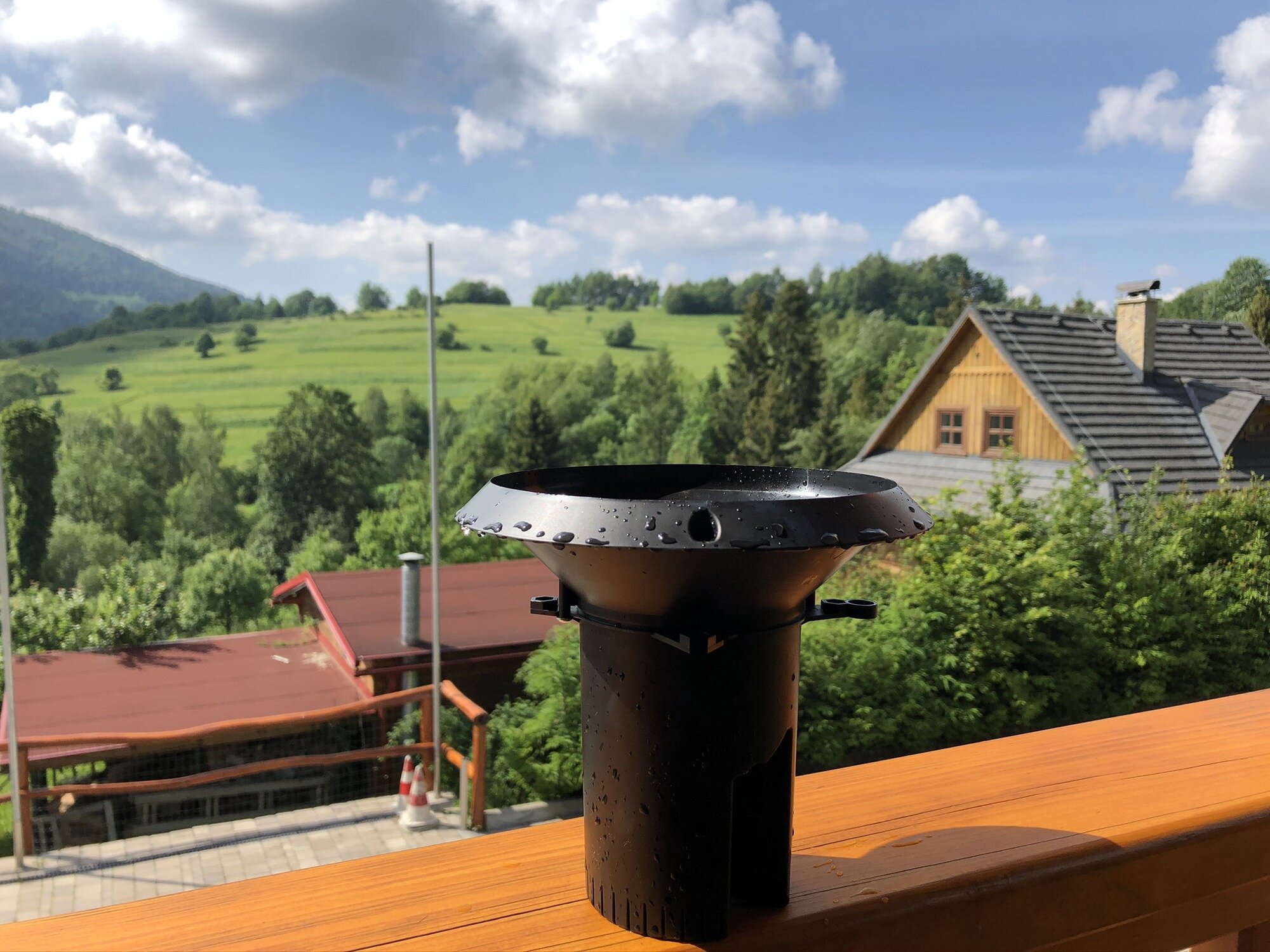 MeteoRain IoT Compact wireless rain gauge on a cottage porch.