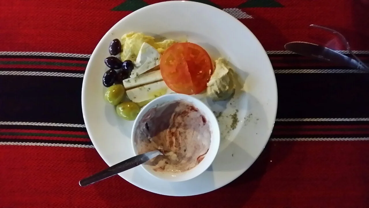 El desayuno del hostal fue algo diferente. Amaneció muy temprano. Tuve una llamada de trabajo que me hizo estar listo antes de tiempo.
Desperté a charly y vajamos al comedor pero todo estaba cerrado. Se nos hizo raro, vimos el exact time de Google petra y nos habíamos despertado una hora ántes.
Así que nos fuimos a recuperar sueño y regresamos más tarde.
Los desayunos de los hostales hoteles son muy diferentes a los que estamos acostumbrados.
Son a base de frutos secos y frutos curtidos. Generalmente los cultivan las mismas personas del lugar. Así que puede ser descortés no terminarte el plato.
Aquí hubo algo diferente. Te hacían un omelet al gusto. Luego le agregabas olivos, aceitunas y quesos locales.
Siempre acompañado de un buena café y avena o cereal.