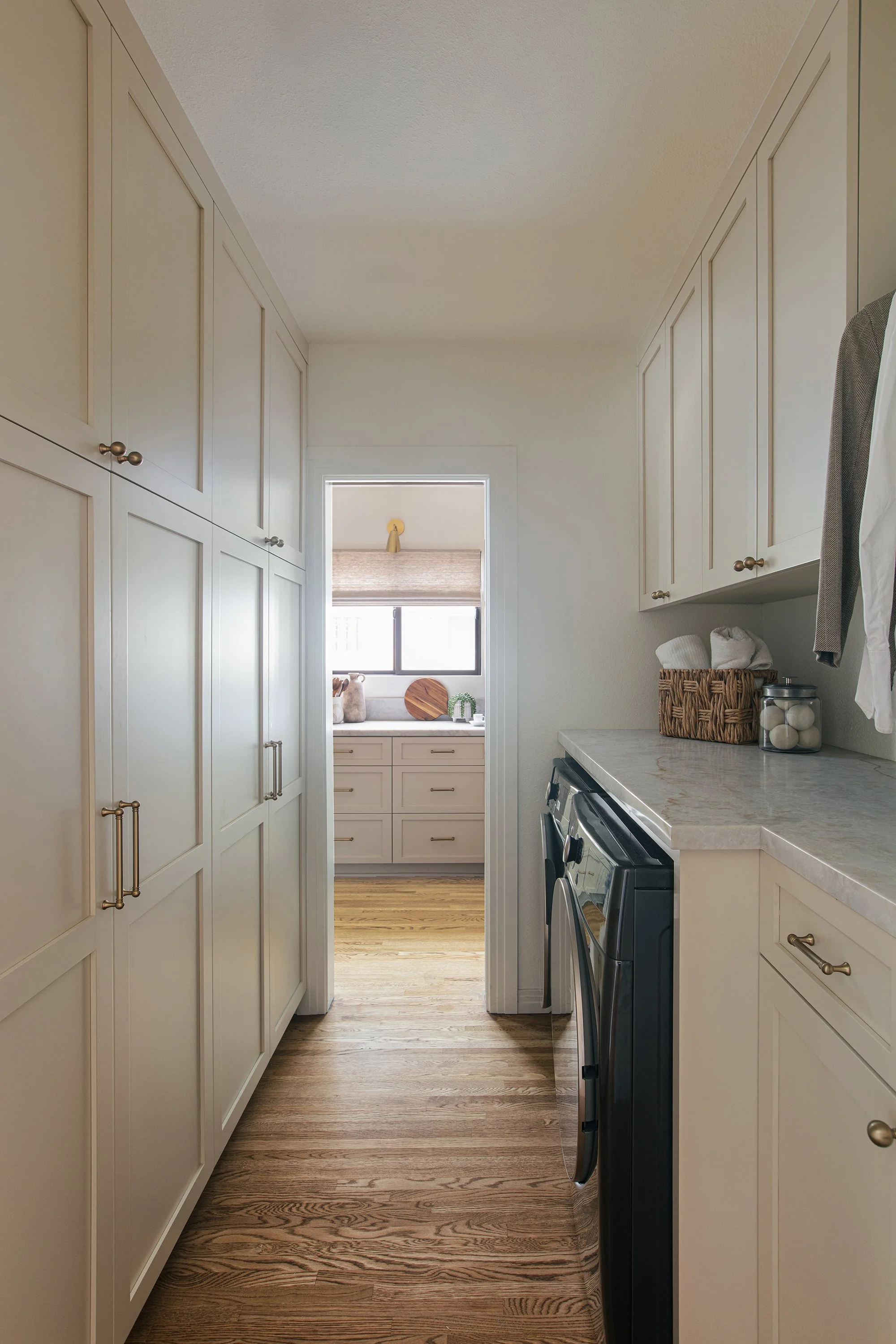 brass hardware, cream cabinets, vintage lighting, taj mahal stone, aged brass light fixtures, aged brass, vintage kitchen, laundry room renovation, ivory cabinets