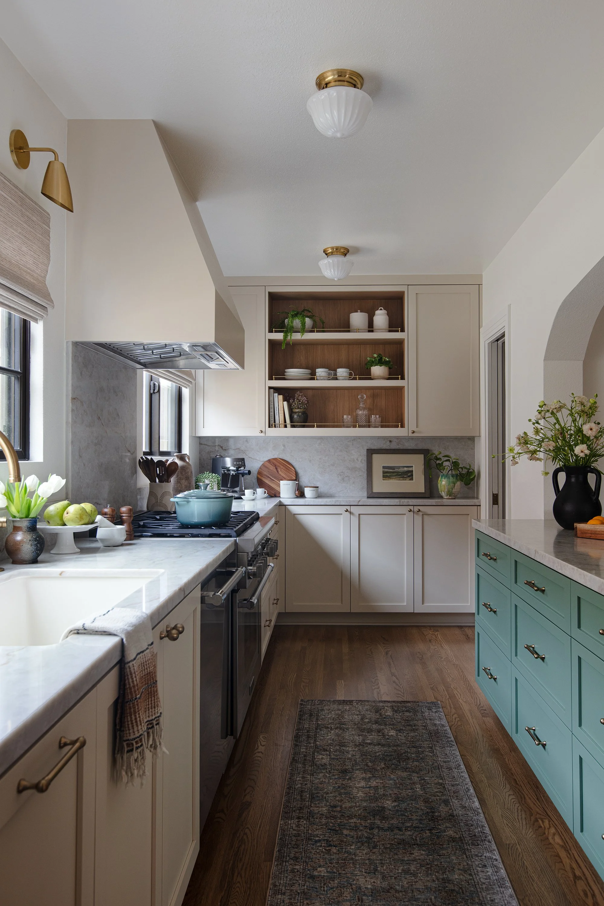 sage green cabinets; aged brass hardware, gallery rail, cream cabinets, vintage lighting, taj mahal stone, aged brass light fixtures, aged brass, vintage kitchen, kitchen renovation, white oak