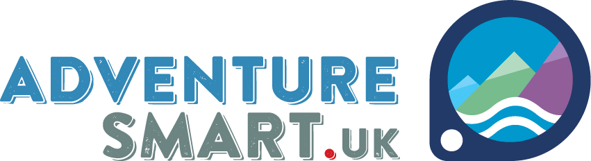 the words Adventure Smart . UK are displayed in a bold uppercase sans serif font next to a graphic of a map location icon in dark blue with a stylised graphic of three mountains and the sea inside.
