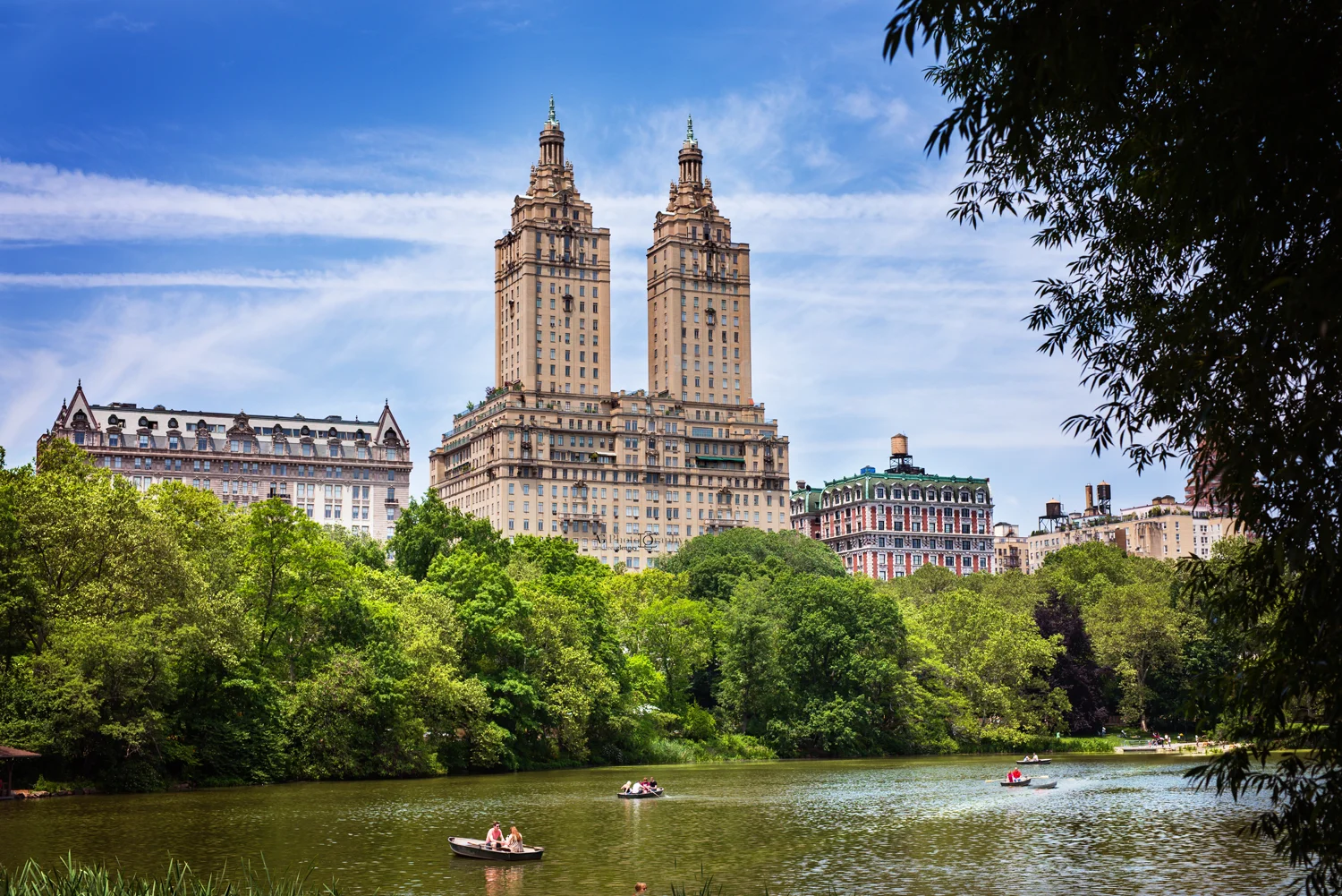 Boats on water in Central Park with The Eldorado building in the background in Central Park, NYC, New York