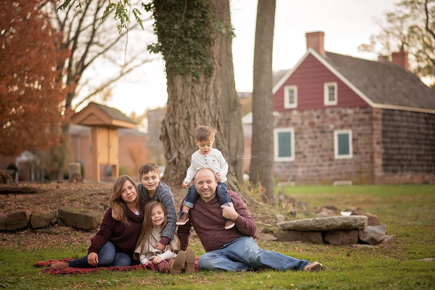Family of 5 sitting on blanket while photographed Bergen County