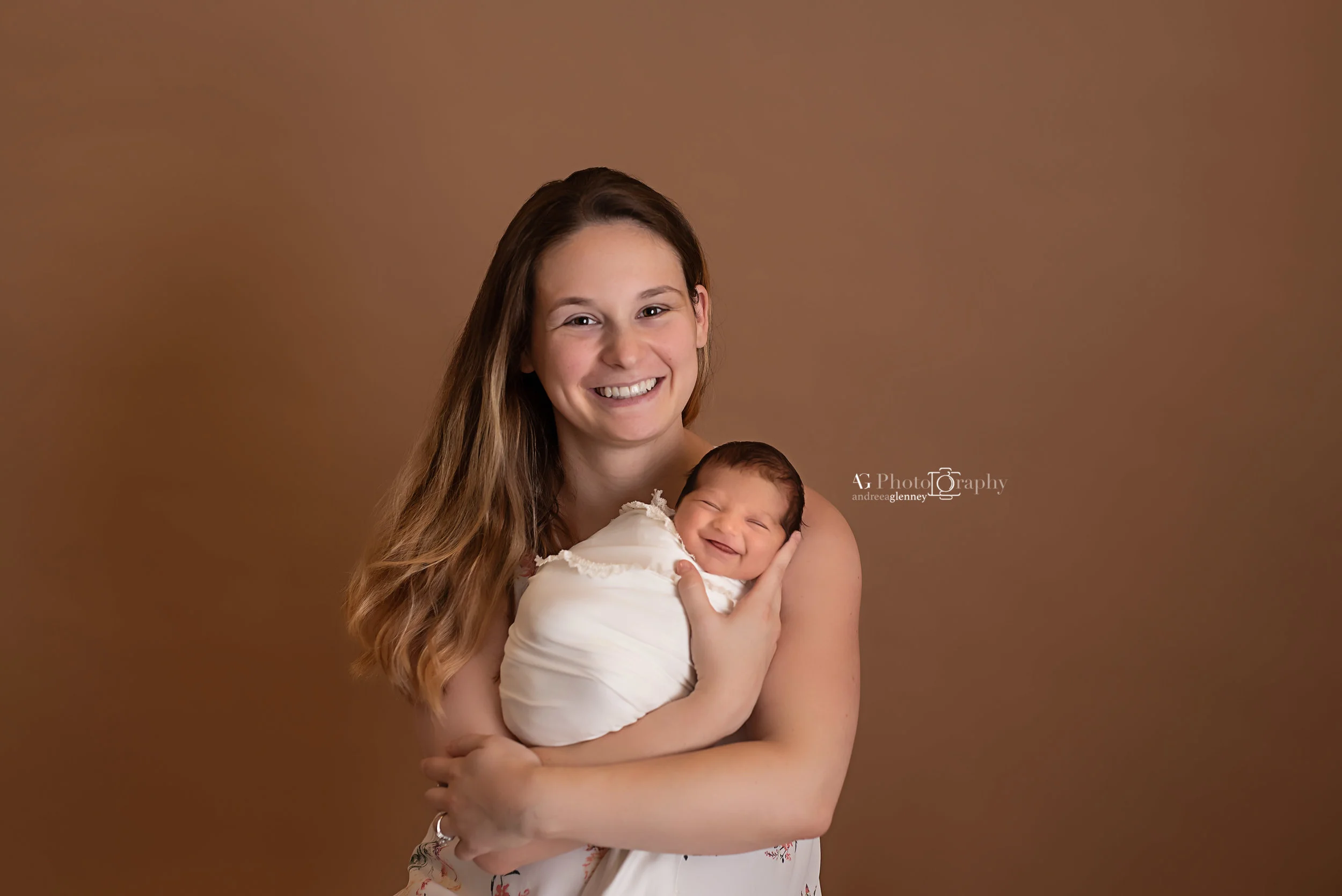 New mom holding her newborn both smiling to the camera