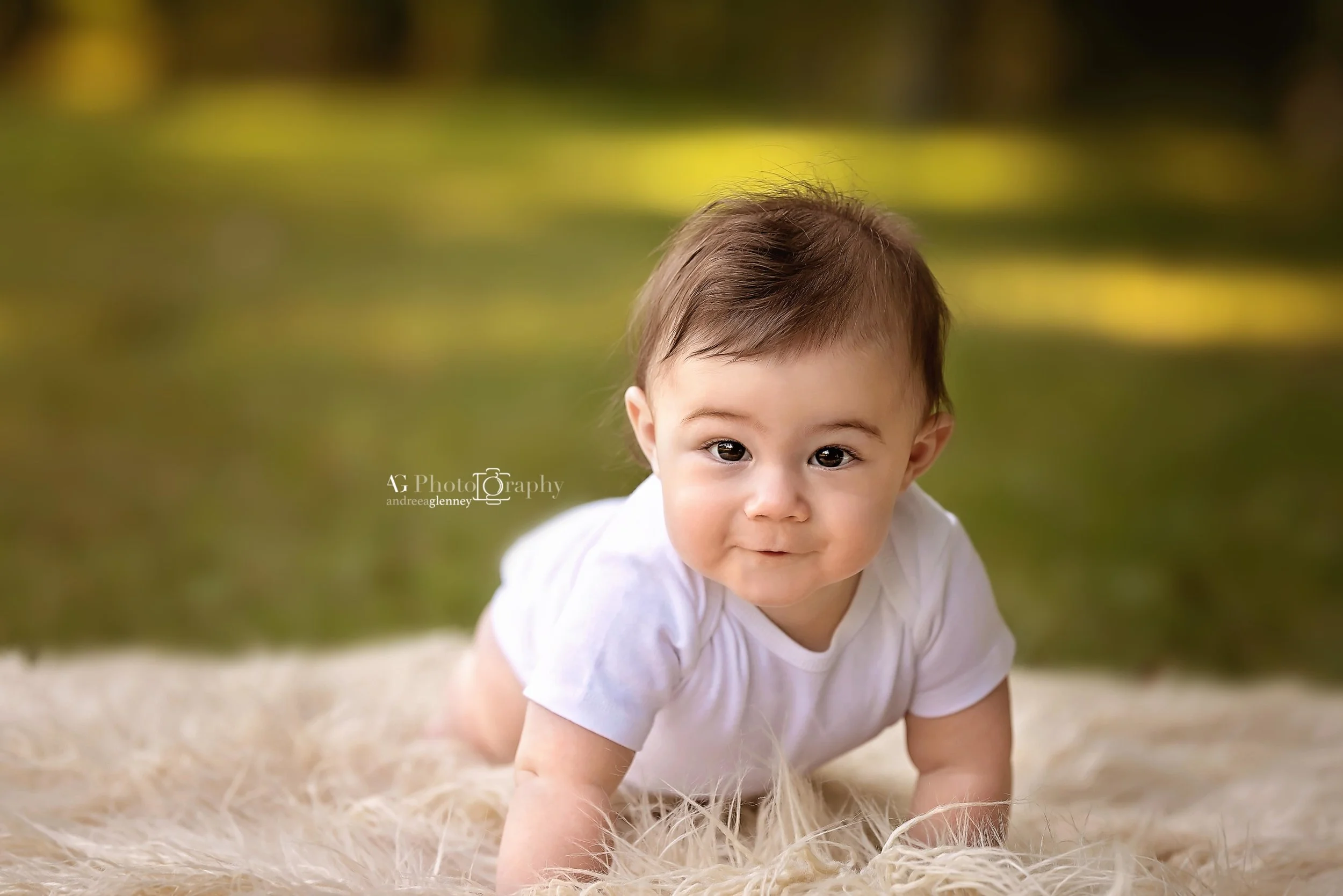 Baby boy looking at the camera while crawling photographed outdoor on a blanket in Bergen County, New Jersey