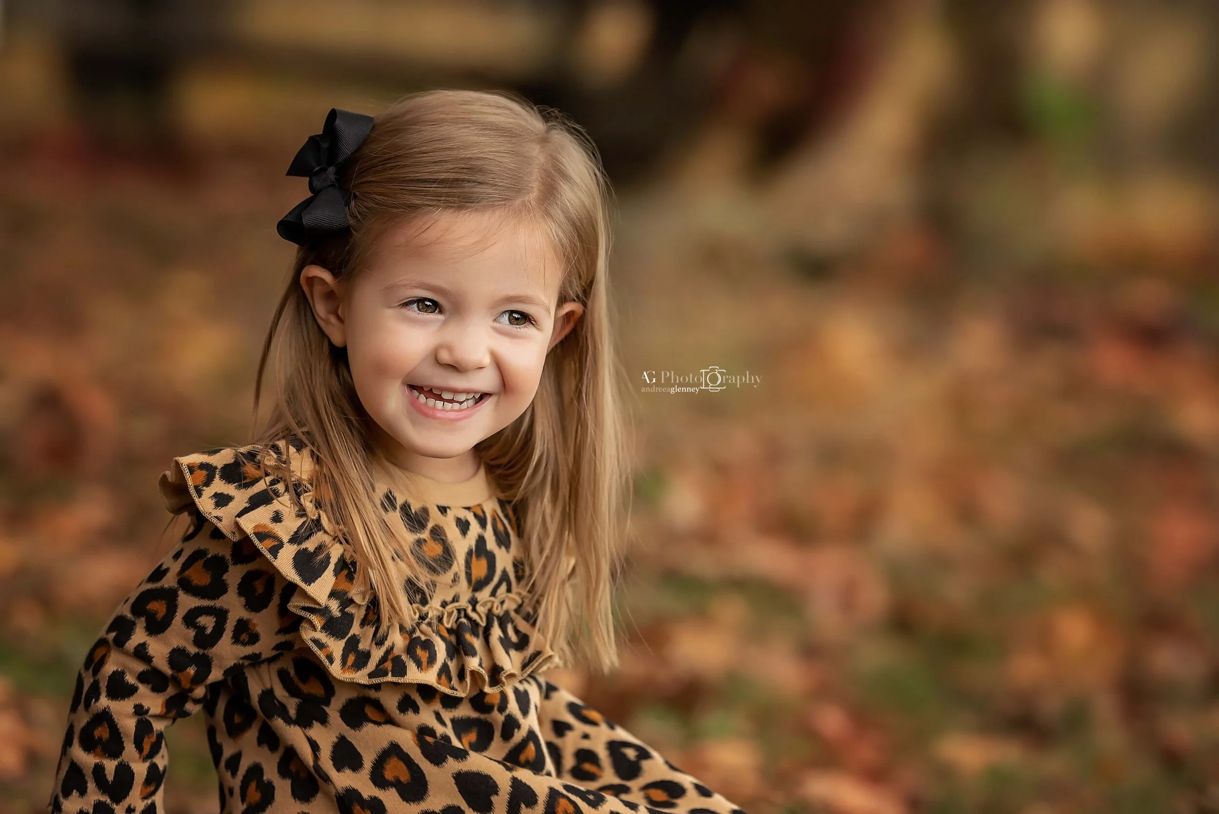 Little girl smiling while photographed during a fall session outdoor in Bergen County, NJ