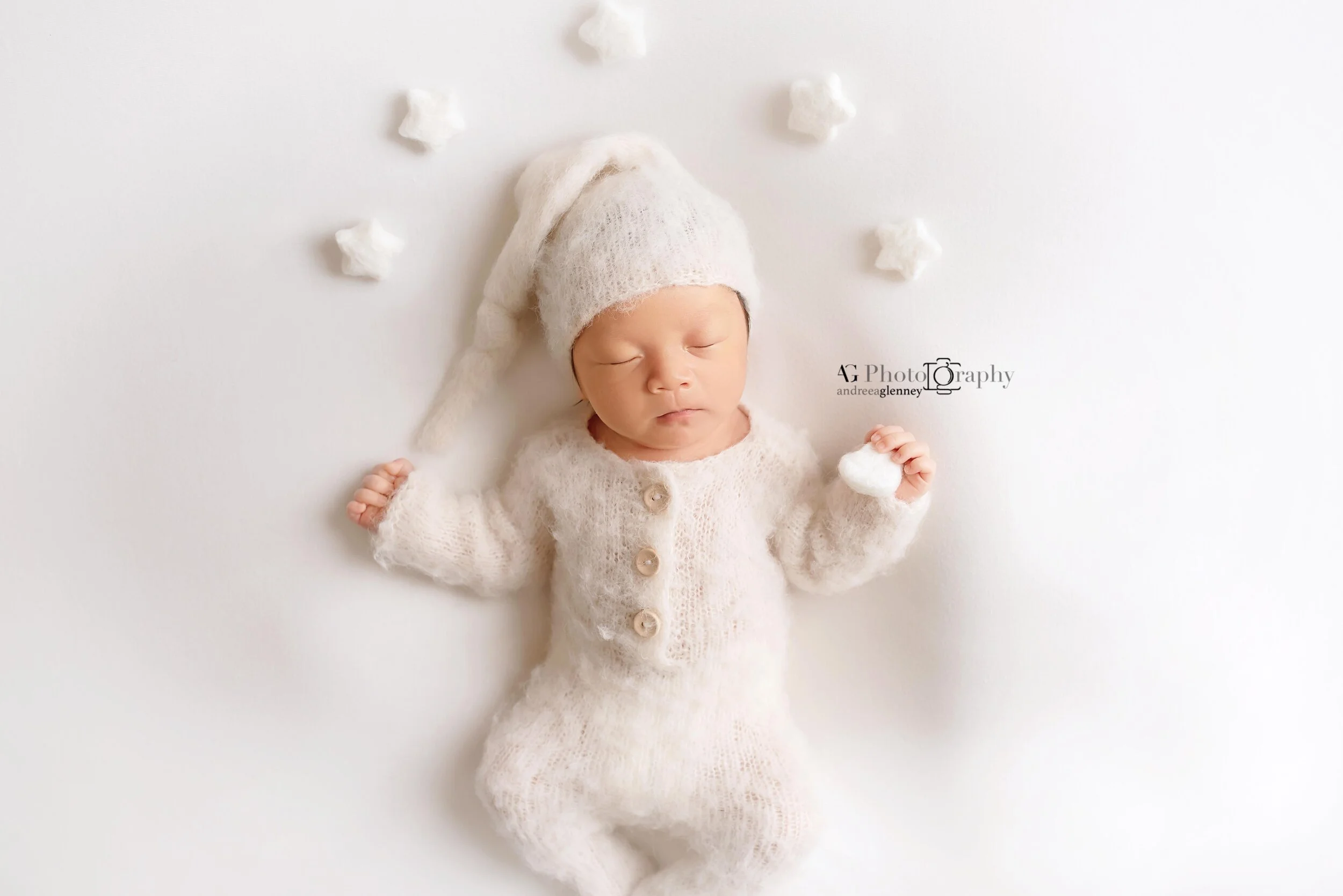 Baby boy photographed on his back while sleeping safely wearing a white romper in Bergen County studio