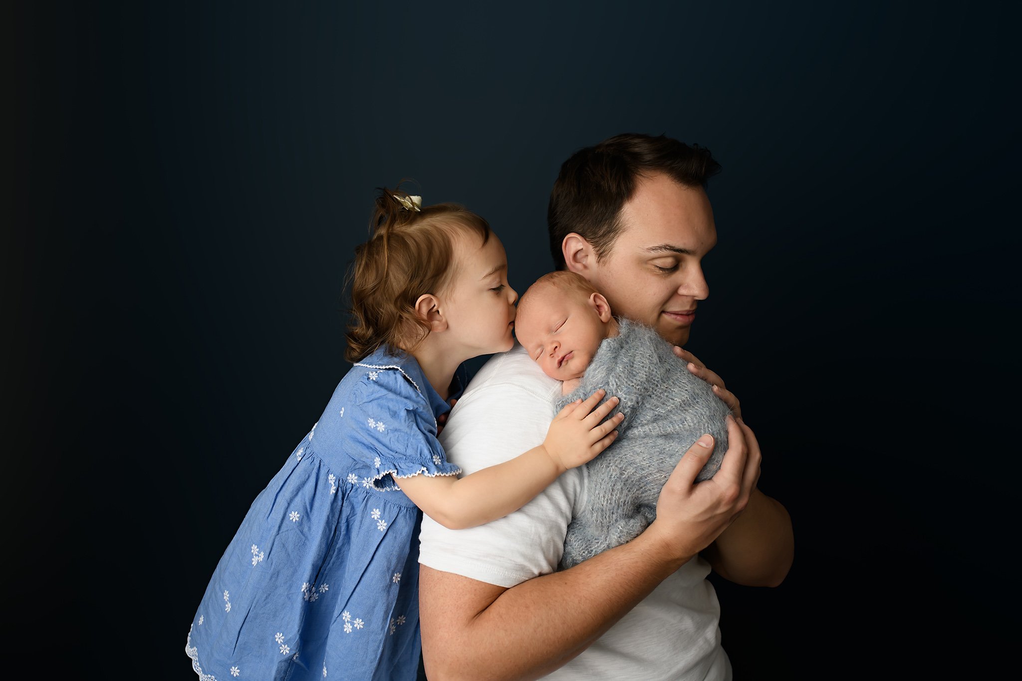 Newborn baby boy with big sister and dad pose