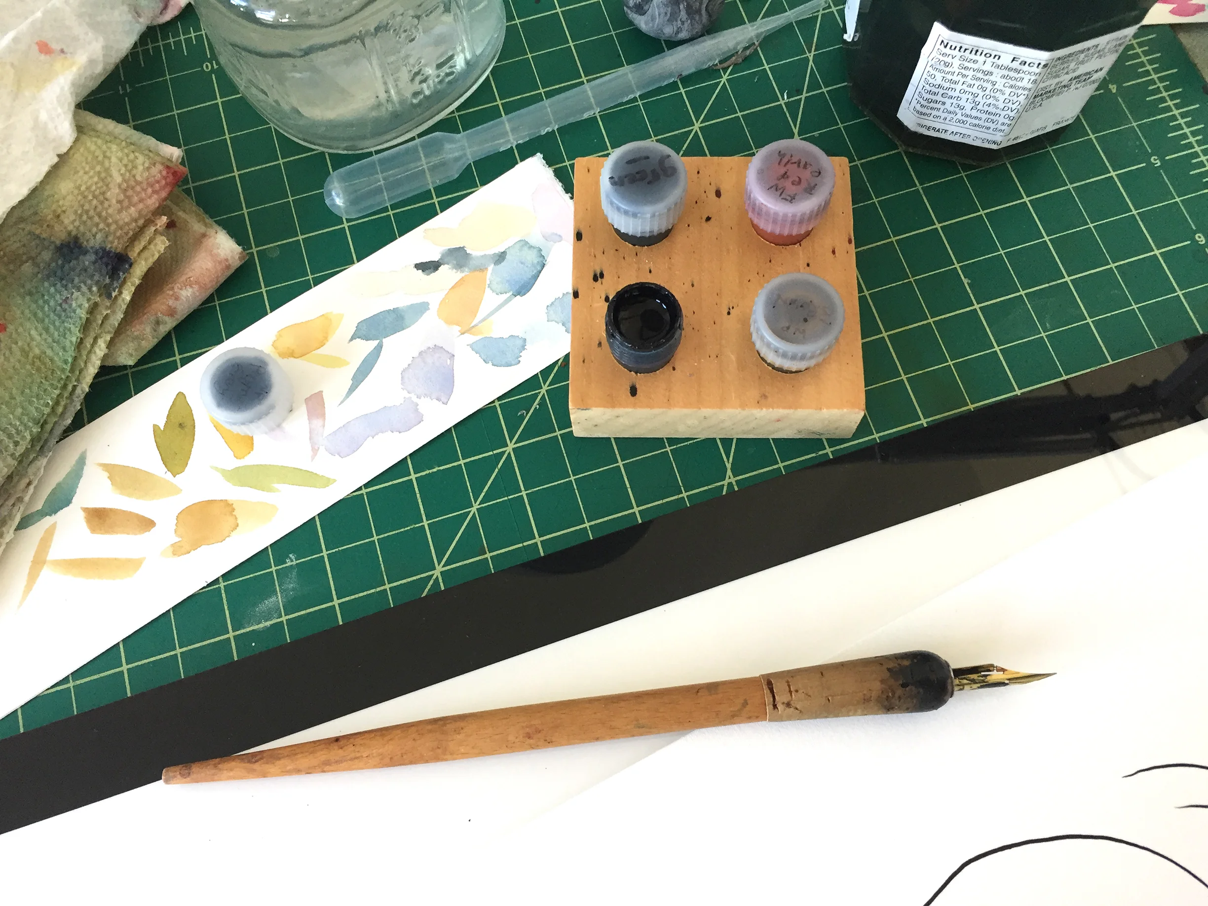 This is what I ink with - a dip pen with a G-nib in it, and FW acrylic ink . I decant the ink into these little things called Dinky Dips , which are the perfect depth for just getting your nib in there and not making a big mess. I love Dinky Dips. This ink is also great because it’s completely waterproof, and there are tons of colors so you can mix up just the right shade. I made my own dark green for this book.