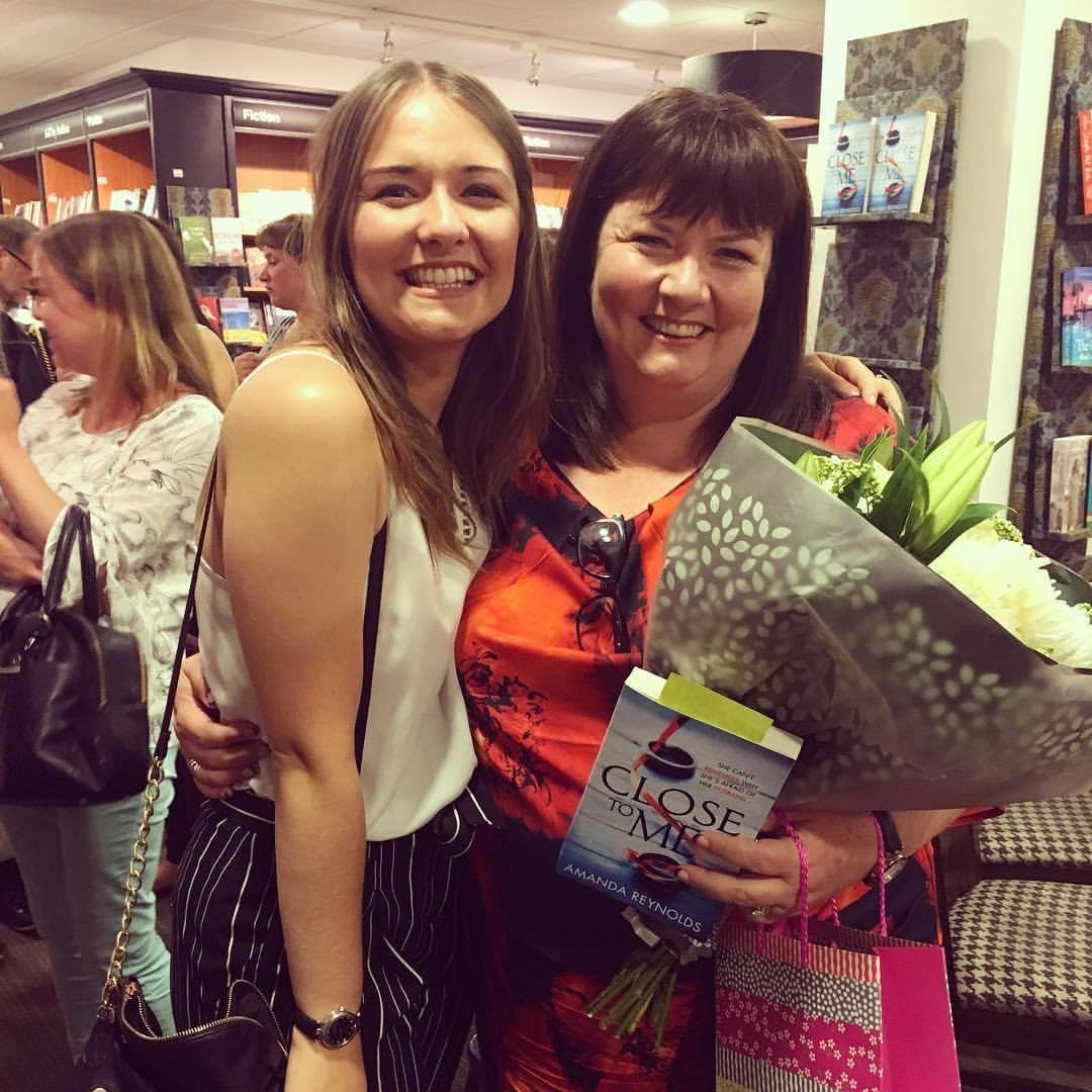 Happy with flowers and book in hand after the signing