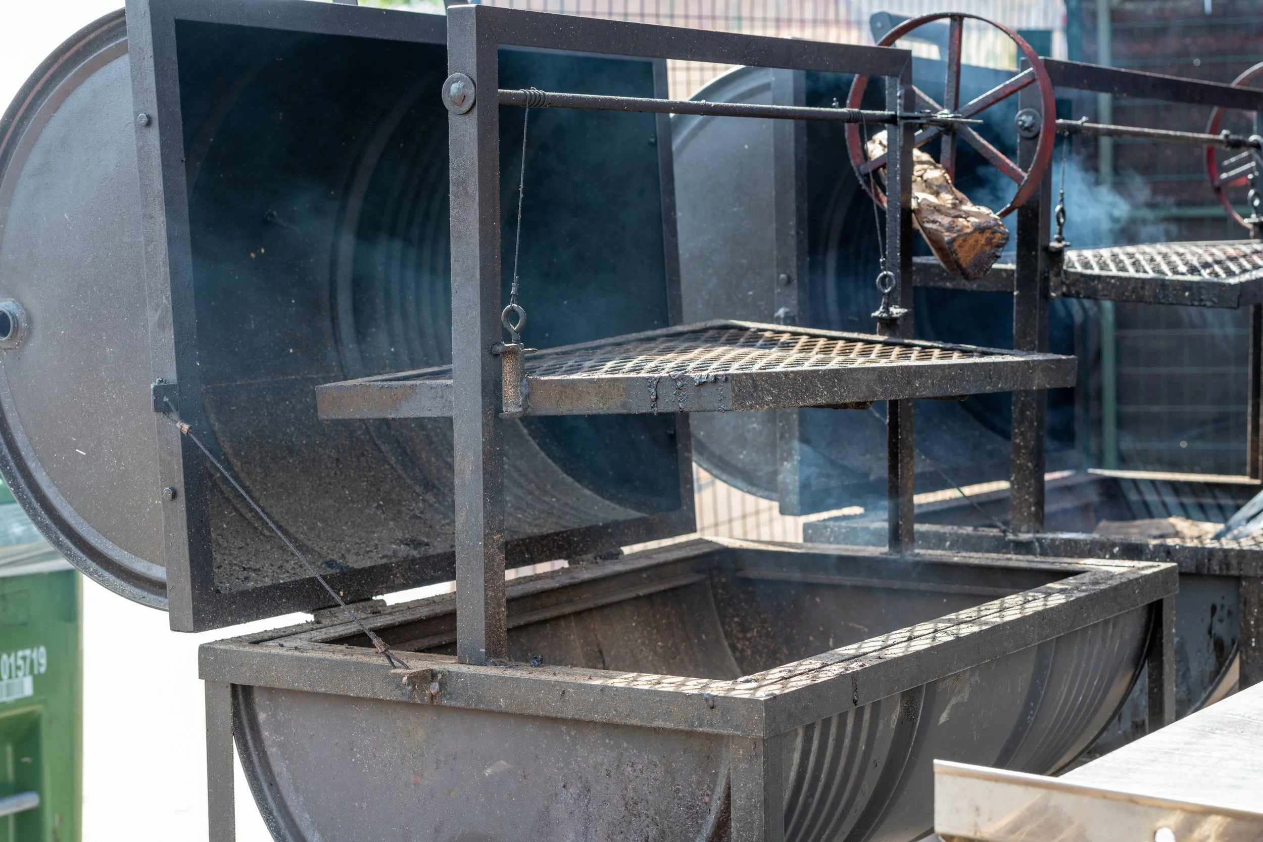 Santa Maria style grill with adjustable crank wheel cooking over wood fire