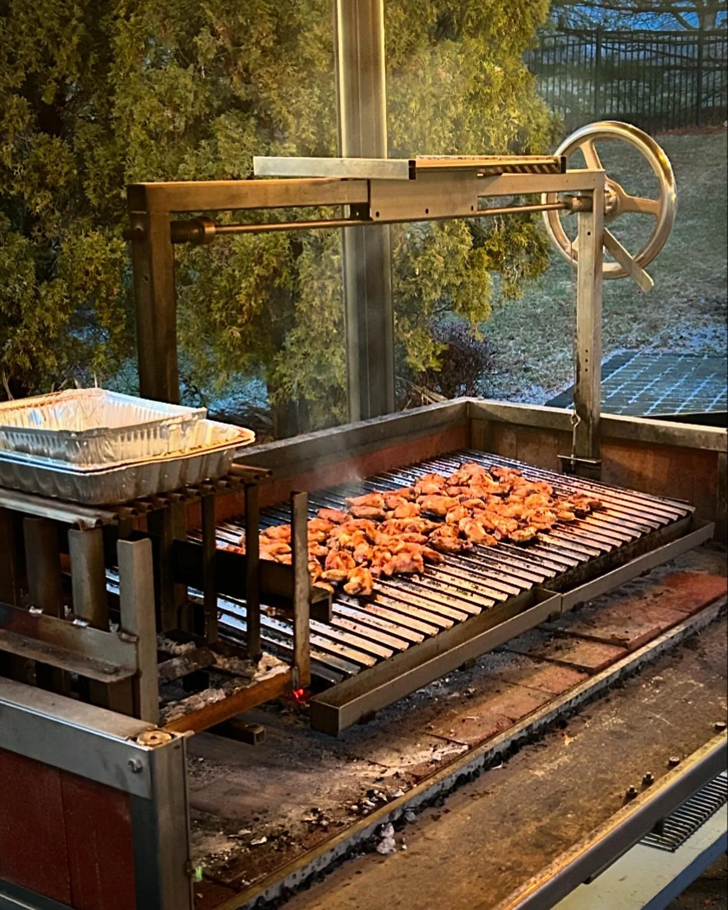 A lot if wood-fired chicken wings waiting to be off-loaded and served. 
.
.
.
#grilling #outdoorkitchen #woodfired #parrilla #outdoorliving #grill #asado #patio #backyard #luxuryhome #woodfiredgrill #bbq #outdoorcooking #argentiniangrill #grilledapps