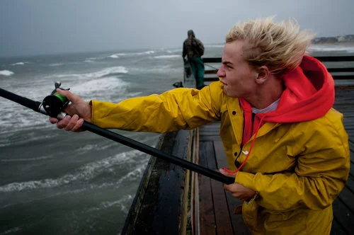 USA. Nags Head, North Carolina. 2008. "Do you need a fish that bad?" I shouted at this boy as he repeatedly cast a line into the heaving sea. "Do you need a photo that bad?" he shouted back. We ended up agreeing that we were both a little crazy for being out on the Nags Head Pier during a nor'easter.