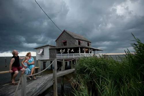 USA. Nags Head, North Carolina. 2010. My neighbors Billy and Sandra Stinson watch a squall roll over their house on Roanoke Sound. Hurricane Irene destroyed the place last August.