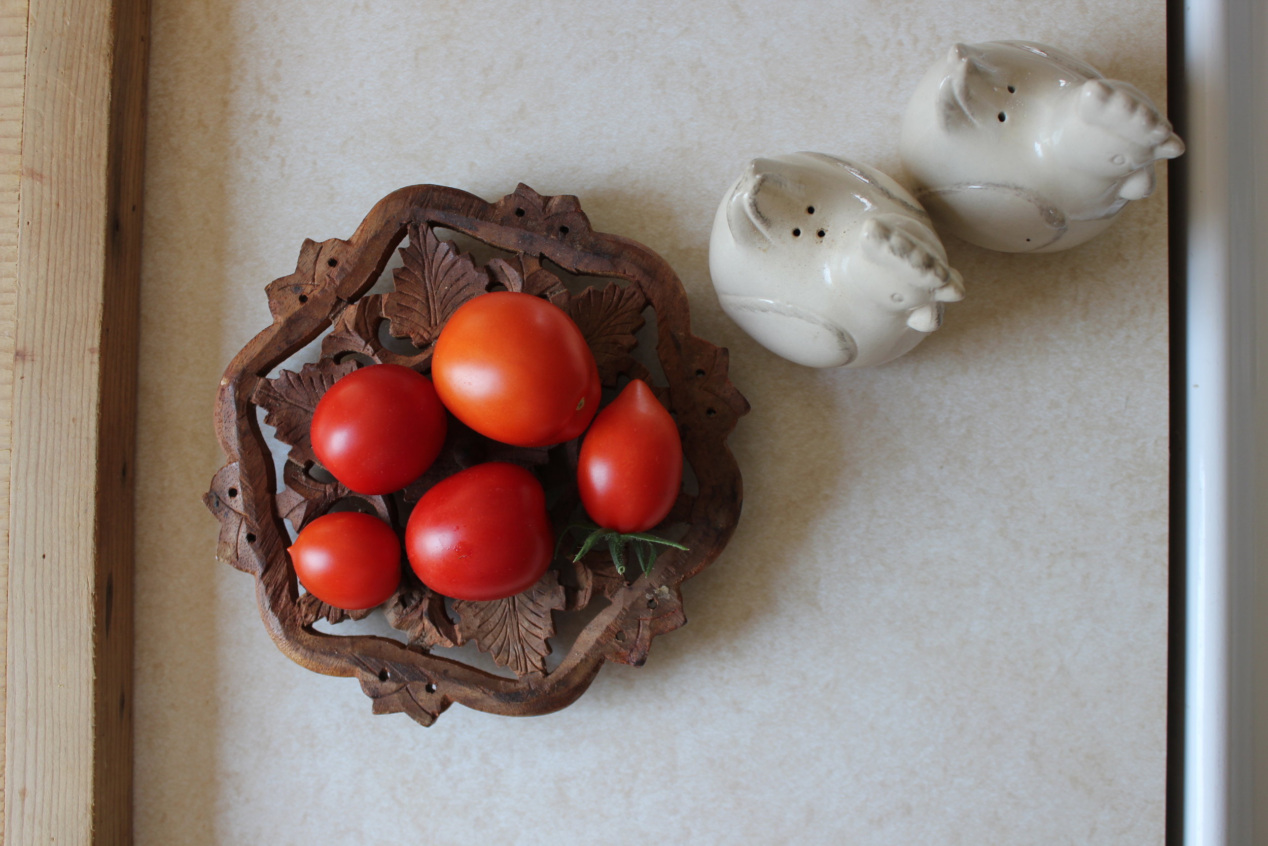 fresh tomatoes and rooster shakers at farm house.JPG