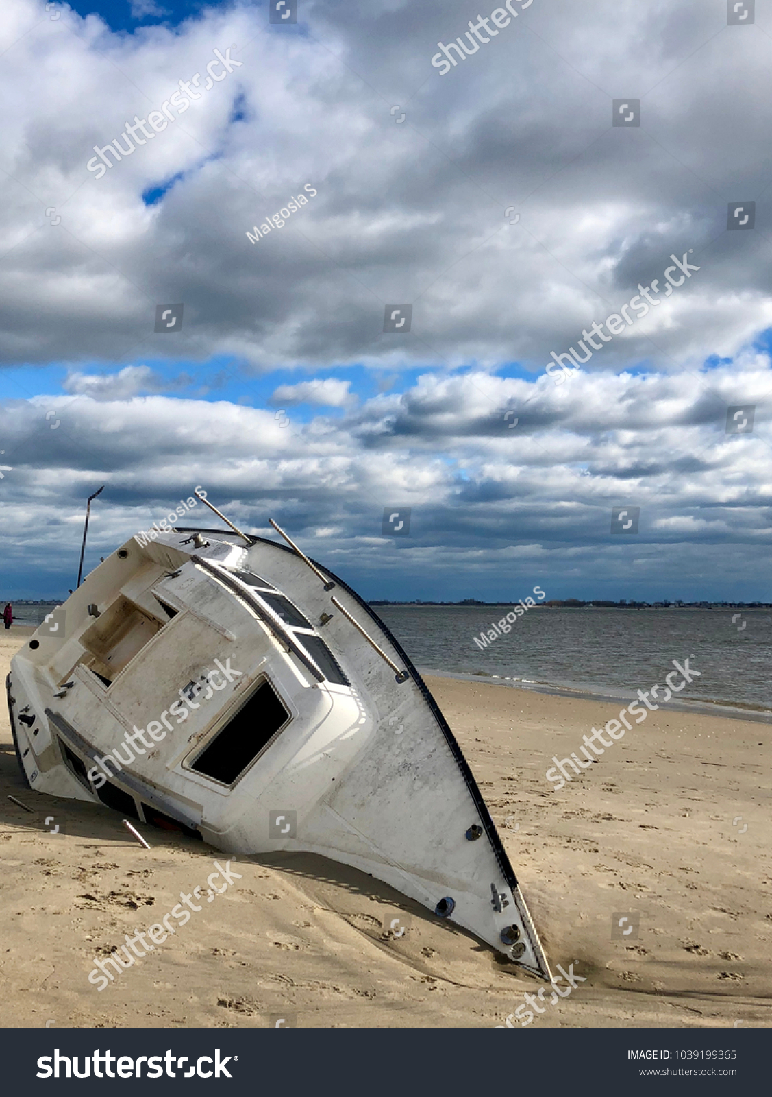 Overturned boat washed ashore by strong storm on Plumb Beach, Brooklyn, NY.